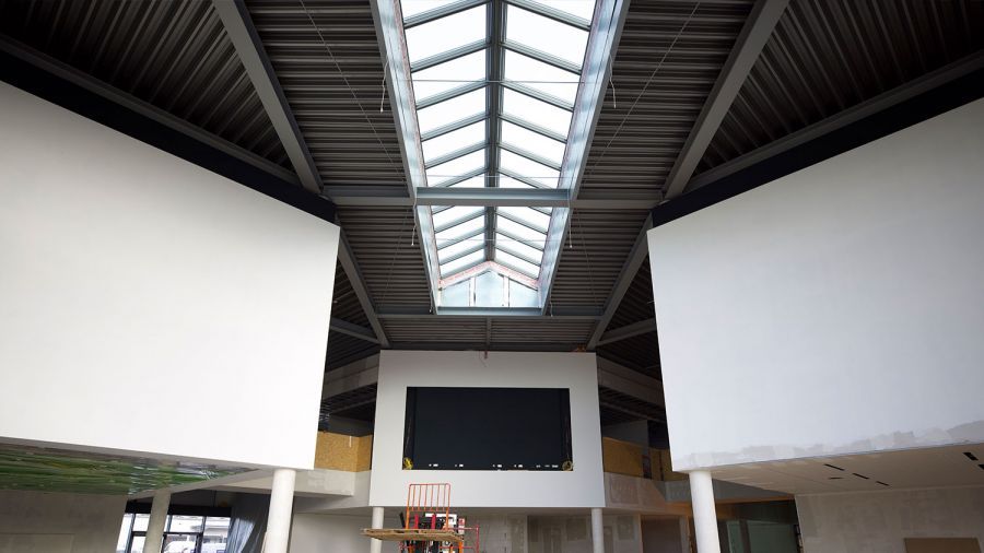 Neues Dach von Innen und Verkaufsraum mit großen Monitoren an den oberen Wänden.